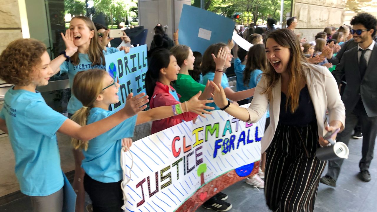 Kelsey Juliana of Eugene, Oregon, one of Juliana's lead plaintiffs, greets supporters outside a federal courthouse in Portland in 2019.