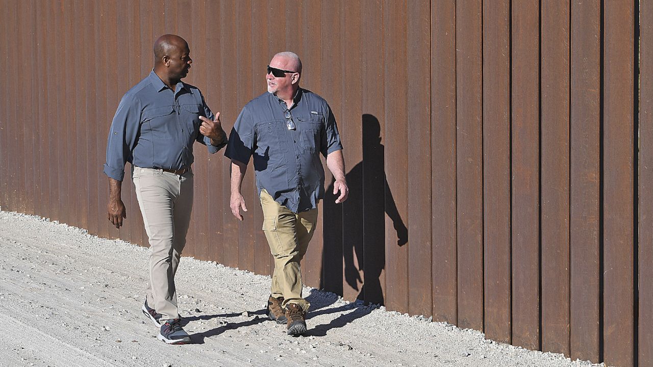 South Carolina Sen. Tim Scott walks  with an unidentified friend along the bollard-style border wall, southwest of Yuma, Arizona, on August 4, 2023. 