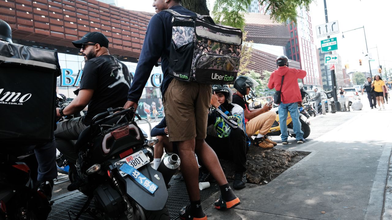 Delivery workers wait outside of a restaurant on July 07, 2023 in New York City. (Photo by Spencer Platt/Getty Images)