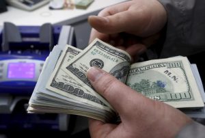 Dollar edges lower ahead of hefty data dump