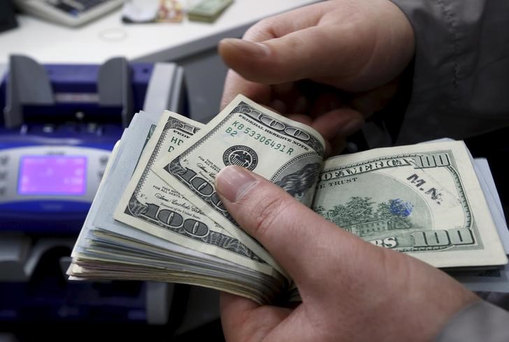 Dollar edges lower ahead of hefty data dump